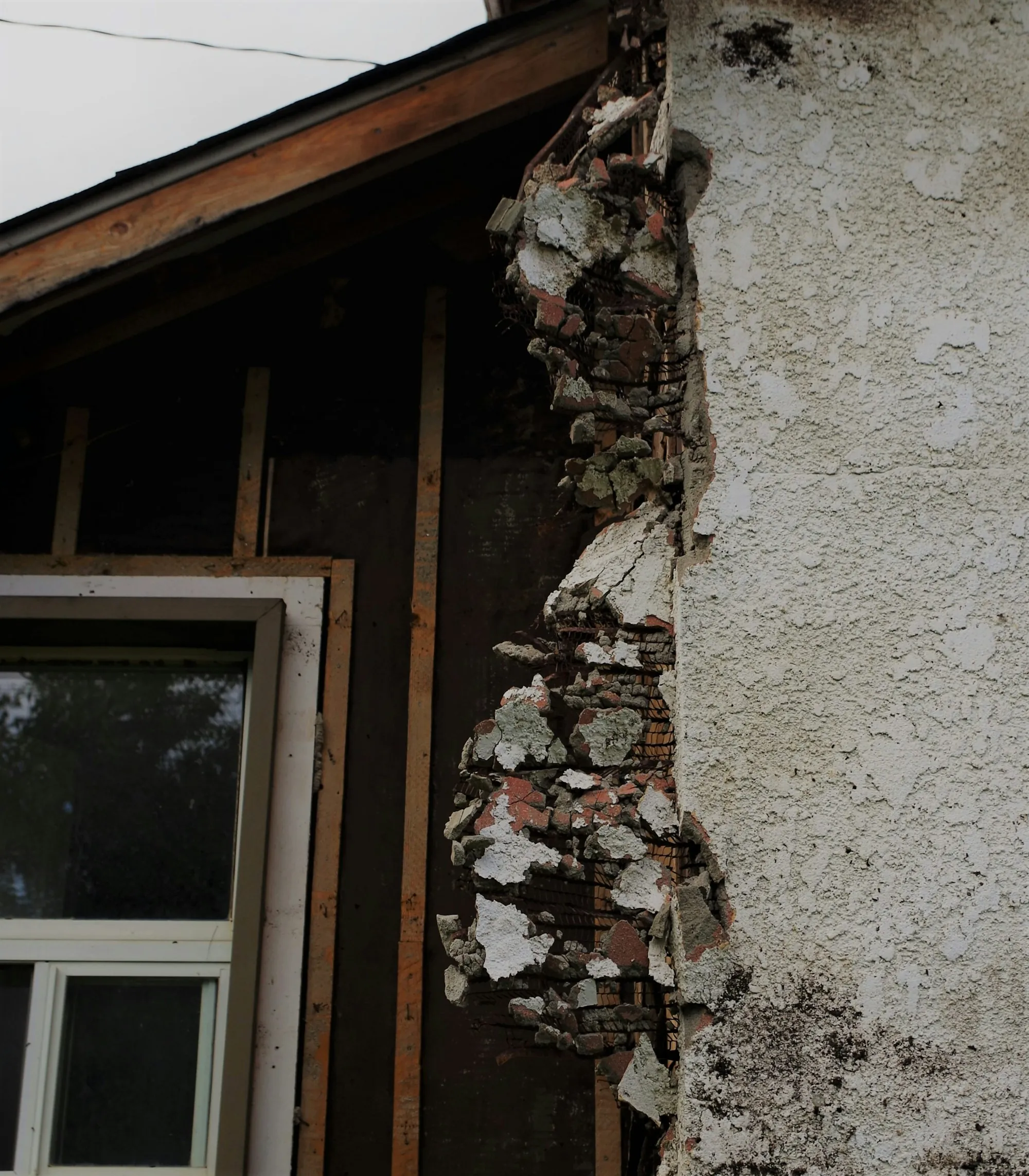 Damaged plaster wall beside an old window